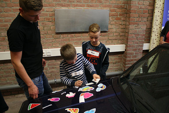 Kinder beim Bekleben eines Autos